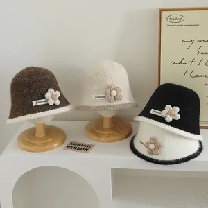 Détail de bobs en tricot avec fleurs en tissu et étiquettes sur des présentoirs