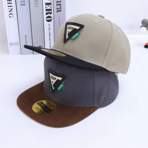 Detalle de gorras snapback bicolor con parches triangulares y visera plana