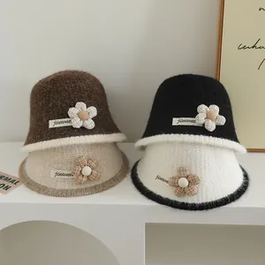 Détail de bobs en tricot avec fleur à carreaux et bord contrasté en quatre couleurs