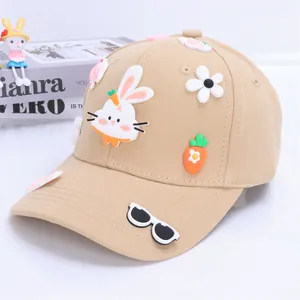 Detail of beige kids baseball cap with 3D rabbit, carrot, and flower charms