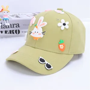 Close-up of light green kids baseball cap featuring 3D rabbit and carrot charms