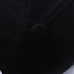 Close-up of the cotton twill texture and top squatchee button on the black baseball cap