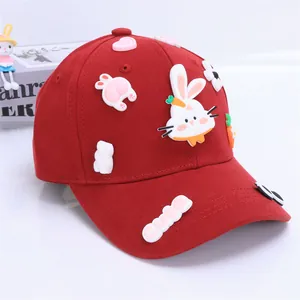Detailed close-up of red cotton baseball cap with 3D cute bunny and carrot decorations