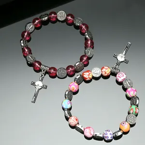 Detailed view of religious beaded bracelets with St. Benedict medal and crucifix pendants