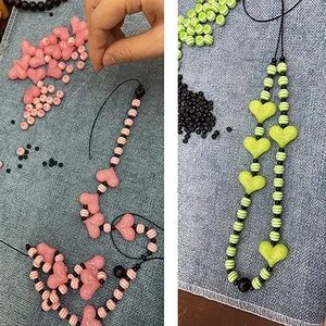 DIY colorful beaded phone chain with pink and green heart beads on denim background