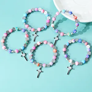 Detailed set of 5 beaded bracelets with floral clay beads and silver crucifix charms