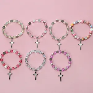 Detail view of seven religious beaded bracelets with heart charms and metal crucifixes