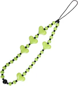 Detail of neon green heart beads and striped spheres on a fashion mobile phone strap