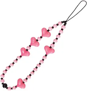 Macro shot of pink heart beads and striped resin balls on a stylish phone charm strap
