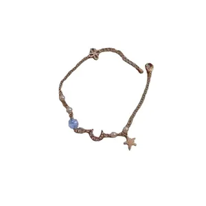 Bracelet doré élégant avec breloques lune et étoile, perles et zircon sur fond blanc pur