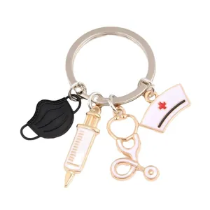 Medical themed keychain with syringe stethoscope and nurse hat charms in gold finish