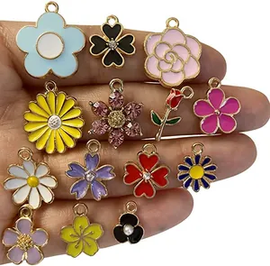 Detalle de dijes de flores en esmalte colorido y colgantes florales para joyería DIY