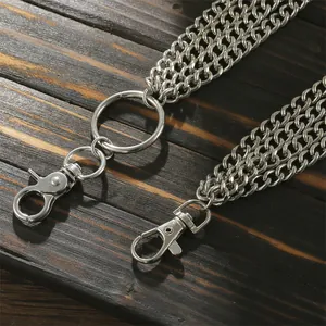 Three-layer silver metal waist chain with punk style lobster clasps on wooden surface