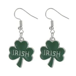Detail of green shamrock earrings with Irish engraving and silver hooks for St. Patrick's Day
