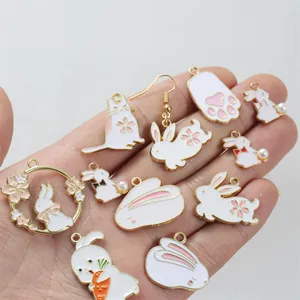 DIY enamel rabbit and cat alloy pendants for jewelry making held in hand for scale