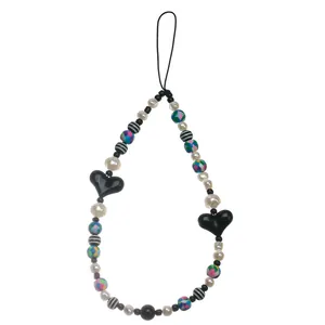 Close-up of bohemian beaded phone strap featuring heart charms and colorful resin beads