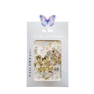 Detail of metallic bow nail art charms in gold and silver within paper packaging
