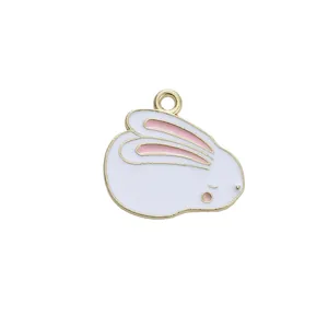 Close-up of a white enamel rabbit charm with pink ears and golden alloy metal frame