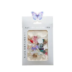 Macro shot of assorted resin nail art charms featuring bows and shells in a boxed display