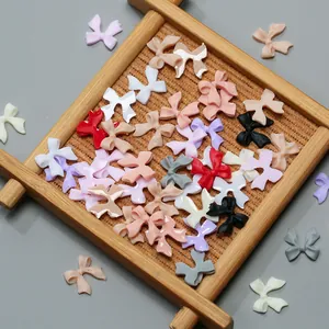 Detailed view of colorful resin bow accessories for DIY nail art and phone case decor