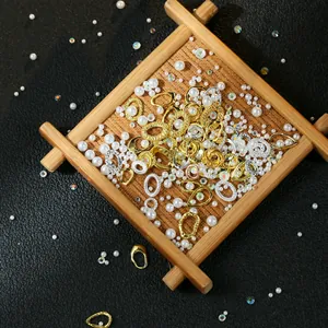Detailed view of DIY jewelry kit with golden metal rings and iridescent pearls