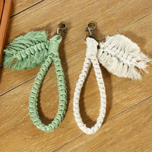 Detailed macro view of bohemian hand-woven cotton leaf tassels with antique bronze clasps