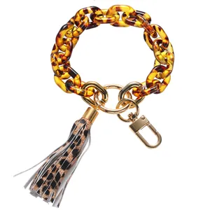 Detail view of amber leopard print acrylic link keychain with leather tassel and gold ring