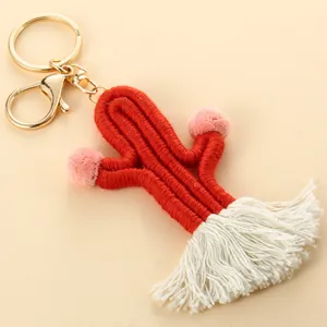 Close-up of handmade woven cactus keychain with soft pink pom-poms and white tassels