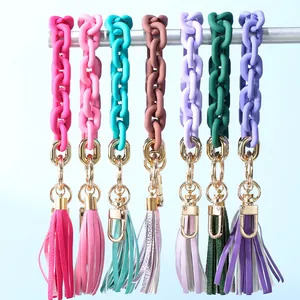 Detail showing various colors of acrylic chain keyrings with leather tassels and gold clips