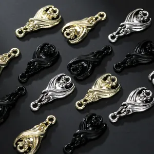 Macro detail of bat-shaped alloy jewelry charms in gold, silver, and matte black finishes