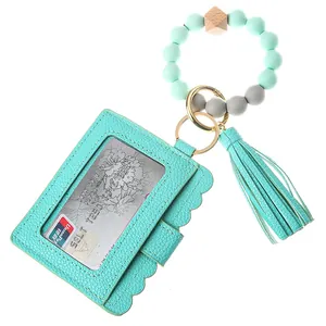 Detail of mint green silicone beads, wooden bead, and scalloped faux leather card holder wallet