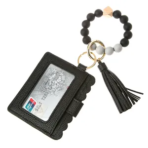 Detail showing wavy edge black leather card holder with silicone bead wristlet strap