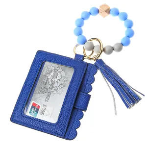 Detail of blue faux leather card holder with silicone beads wristlet and tassel keychain
