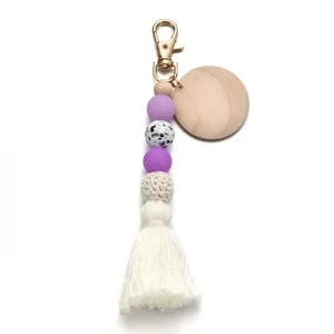 Détail du porte-clés en perles de silicone avec pompon blanc et médaillon en bois