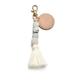 Détail d'un porte-clés boho avec perles en silicone et gland en coton blanc élégant