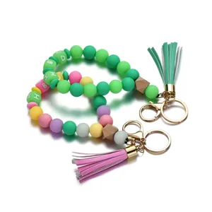 Détails des bracelets en perles de silicone avec perles en bois et pompons colorés