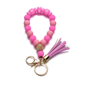 Détail macro de perles en silicone rose avec lettres HBD et pompon en cuir élégant