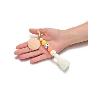 Porte-clés en perles de silicone avec pendentif bois et pompon en coton blanc