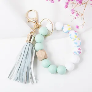 Detail of beaded keychain wristlet with mint silicone beads, wood hex bead, and leather tassel