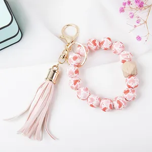 Detail of pink heart printed beads with wooden bead and tassel on a golden keychain