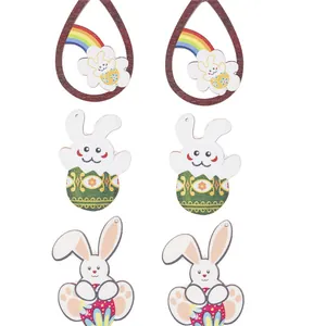 Three pairs of wooden Easter earrings featuring rabbits and colorful eggs on white background