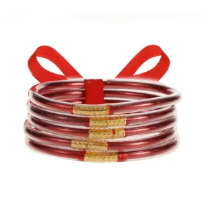 Detalle de pulseras de silicona con purpurina roja y cierres metálicos dorados elegantes