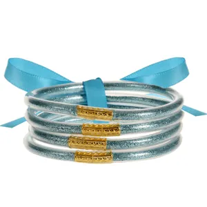 Primer plano de set de 4 brazaletes de resina con purpurina azul y cierres dorados tallados