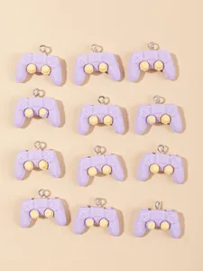 Flat lay of 12 purple resin game controller charms with yellow joysticks and metal rings