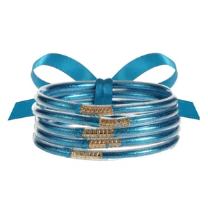 Detalle de 5 pulseras de silicona con purpurina azul y cierres dorados con textura