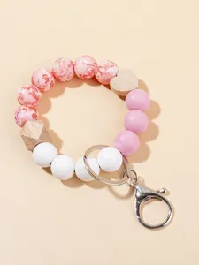 Detalle del llavero de cuentas con esferas de silicona rosa y colgante de madera de corazón