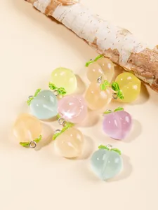 Vue macro de pendentifs pêche en résine colorée avec anneaux argentés pour bijoux DIY