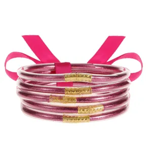 Detalle del set de 5 pulseras rosa con purpurina y conectores de metal dorado texturizado