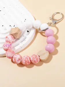Detalle del llavero de cuentas de silicona rosa, corazón de madera y cierre de metal plateado