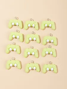 Flat lay macro of twelve light green mini resin game controller charms with metal rings